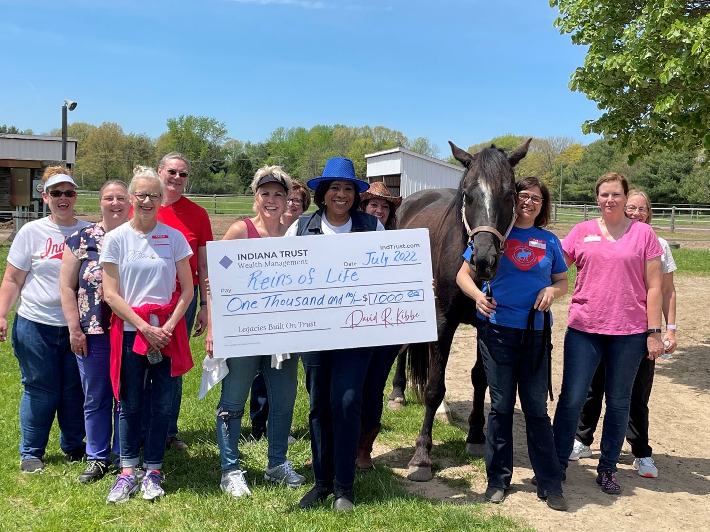 Indiana Trust Wealth Management group photo with Dorota Janik, Executive Director, at Reins of Life in South Bend, Indiana